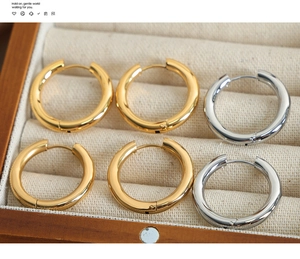 Polished gold and silver geometric hoop earrings arranged in an elegant jewelry box