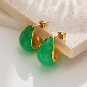 Macro de boucles d'oreilles en titane doré avec résine verte en forme de gouttelette
