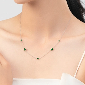 Minimalist S925 silver necklace featuring elegant green cubic zirconia on model's neck