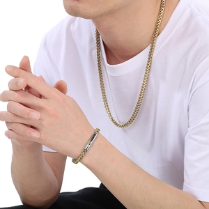 Detail of vintage titanium steel dragon bone chain set worn by male model on white background