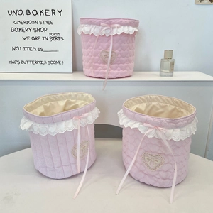 Detailed view of quilted fabric baskets with pink heart patterns and lace ribbon trim
