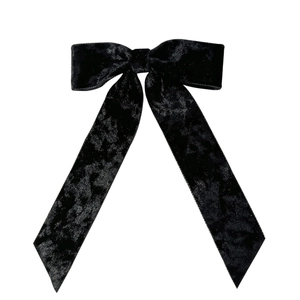 Elegant black velvet bow hair clip with long ribbons in a centered minimalist view