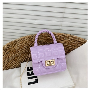 Detail of lavender PVC jelly bag featuring diamond lattice texture and gold twist lock