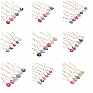 Detail of colorful enamel heart and star charms with evil eye motifs and gold chains
