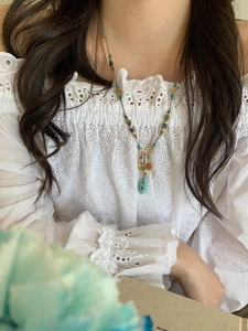 Detail of bohemian turquoise pendant necklace with multi-colored gemstone beads for women
