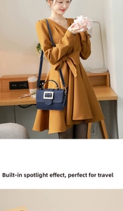 Detail of dark blue leather square bag with large gold metallic buckle and thin strap