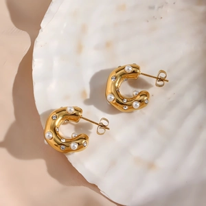 Detail view of 18K gold plated C-shaped earrings with pearls and crystal zircon inlay