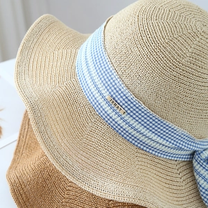 Detail of knit hat texture with blue plaid ribbon and brand metal buckle