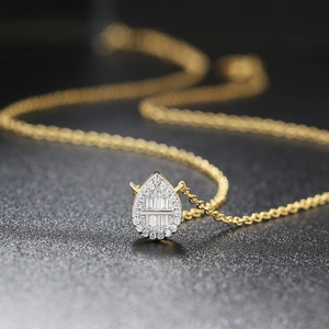 Detailed close-up of water drop pendant with zircon inlay on a golden chain necklace