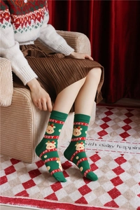 Detailed view of green combed cotton Christmas socks featuring cute reindeer patterns