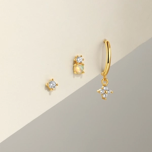 Macro shot of gold-plated silver earrings set with opal stones and sparkling zirconia details