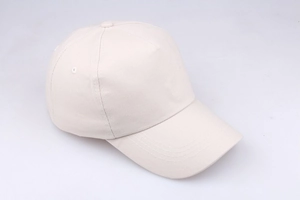 Detailed view of cream-colored cotton baseball cap with ventilation eyelets and stitching