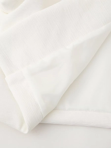 Close-up of white sleeveless puffer vest fabric with horizontal texture and soft inner lining