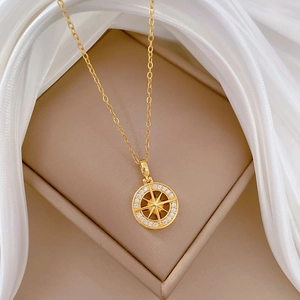 Close-up of a gold starburst medallion necklace with crystals on white silk background
