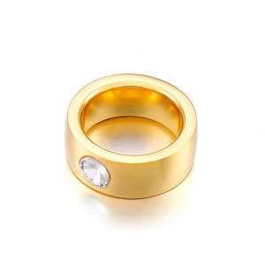 Gold wide band stainless steel ring featuring a four-prong set cubic zirconia stone
