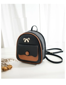 Detail of a mini black fashion backpack with brown piping and a golden bow metal clasp