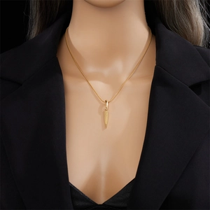 Collana minimalista dorata con ciondolo a foglia e catena a serpente indossata su modella