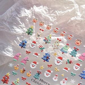 Gros plan d'autocollants 3D de Noël pour ongles avec motifs embossés de Père Noël et rennes