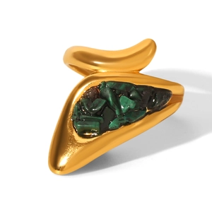 Macro detail of gold-plated stainless steel ring with green stone inlay and textured surface