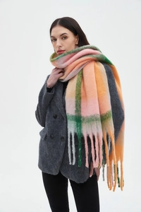 Detail of soft boucle plaid scarf with long fringe in pink, orange, and green tones