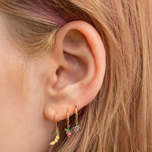 Close-up of colorful fruit charm earrings with banana, strawberry and grape designs