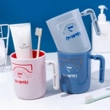 Close-up of wall-mounted plastic tooth brushing cups with ergonomic handle hooks