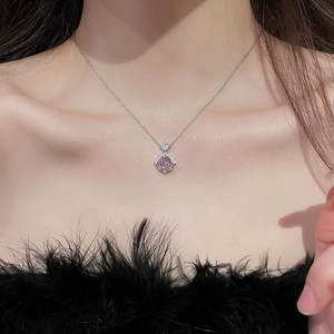 Close-up of 14k gold plated necklace with a sparkling pink gemstone flower pendant