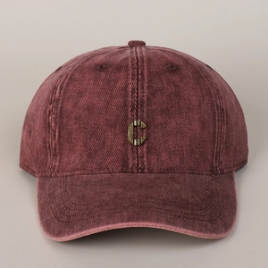 Detail of vintage washed cotton baseball cap with antique bronze metal C initial