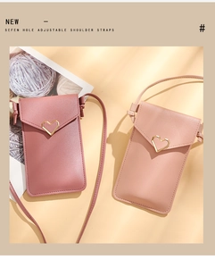Detail of pink and beige leather phone bags featuring golden heart-shaped buckles