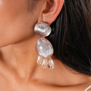 Vue détaillée de boucles d'oreilles multicouches en résine transparente sur le modèle