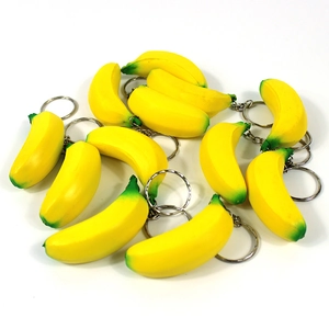 Detailed close-up of cute realistic mini yellow banana keychains with metal chains