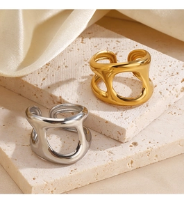 Close-up of gold and silver hollow geometric rings on a stone surface with satin background