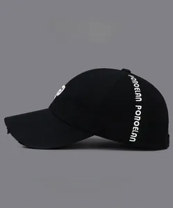 Detail of POROELAN embroidery on black distressed cotton baseball cap with torn brim