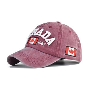 Detail of red washed cotton baseball cap featuring CANADA and 1867 embroidery art