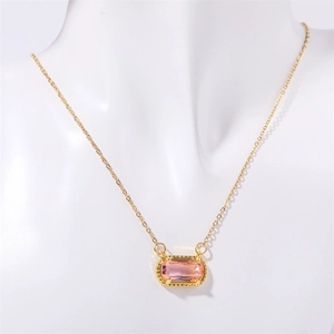 Detail einer Goldhalskette mit einem rechteckigen rosa Edelsteinanhänger auf einer Büste