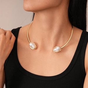 Minimalist gold open collar necklace with baroque pearls worn by a model on the collarbone