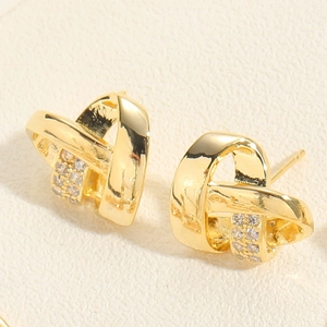 Macro shot of gold-plated twisted knot stud earrings with micro-pave cubic zirconia