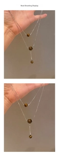 Nahaufnahme der zweilagigen Silberkette mit Tigerauge-Perlen im Y-Design