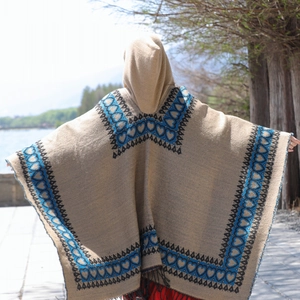 Vue arrière du poncho bohème beige à capuche avec motifs de cœur tribaux bleus