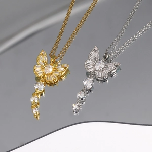 Vue macro des colliers pendentif papillon en or et argent sertis de zircons cubiques