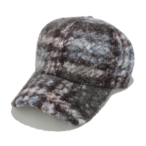 Detailed view of the thick textured plaid wool fabric and stitching on a baseball cap