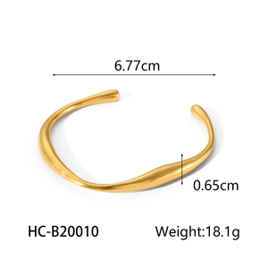 Irregular streamlined gold bangle detailing 6.77cm length and 0.65cm width dimensions