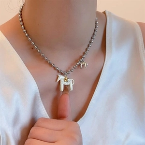 Detailansicht der Silberperlenkette mit weißem Dala-Pferd-Anhänger und goldenen Sternen