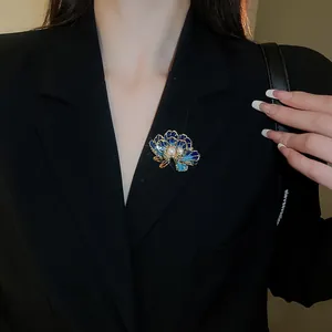 Detail of blue enamel flower brooch with pearl on black suit lapel