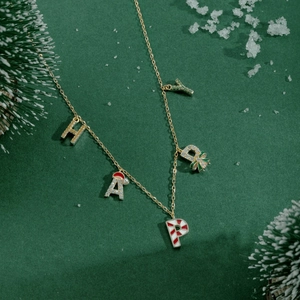 Detail of S925 silver golden HAPPY necklace with festive Christmas candy cane charms