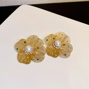 Detail of hollow flower earring with pearl center and sparkling micro rhinestones
