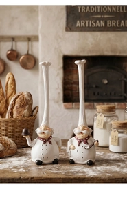 Detailed resin chef figurines with tall hats in a warm rustic kitchen setting