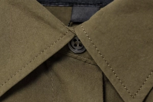 Detailed close-up of olive green shirt collar featuring fine stitching and matte buttons