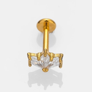 Macro detail of gold stainless steel crown lip stud with a sparkling zircon crystal