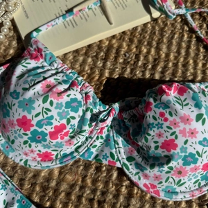 Detailansicht des Bikini-Oberteils mit Blumenmuster, Bügel-Support und Rüschenbesatz